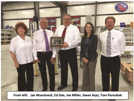 Jan Wuestneck, Ed Doe, Joe Miller, Gwen Arps, Tom Paroubek stand on factory floor with award